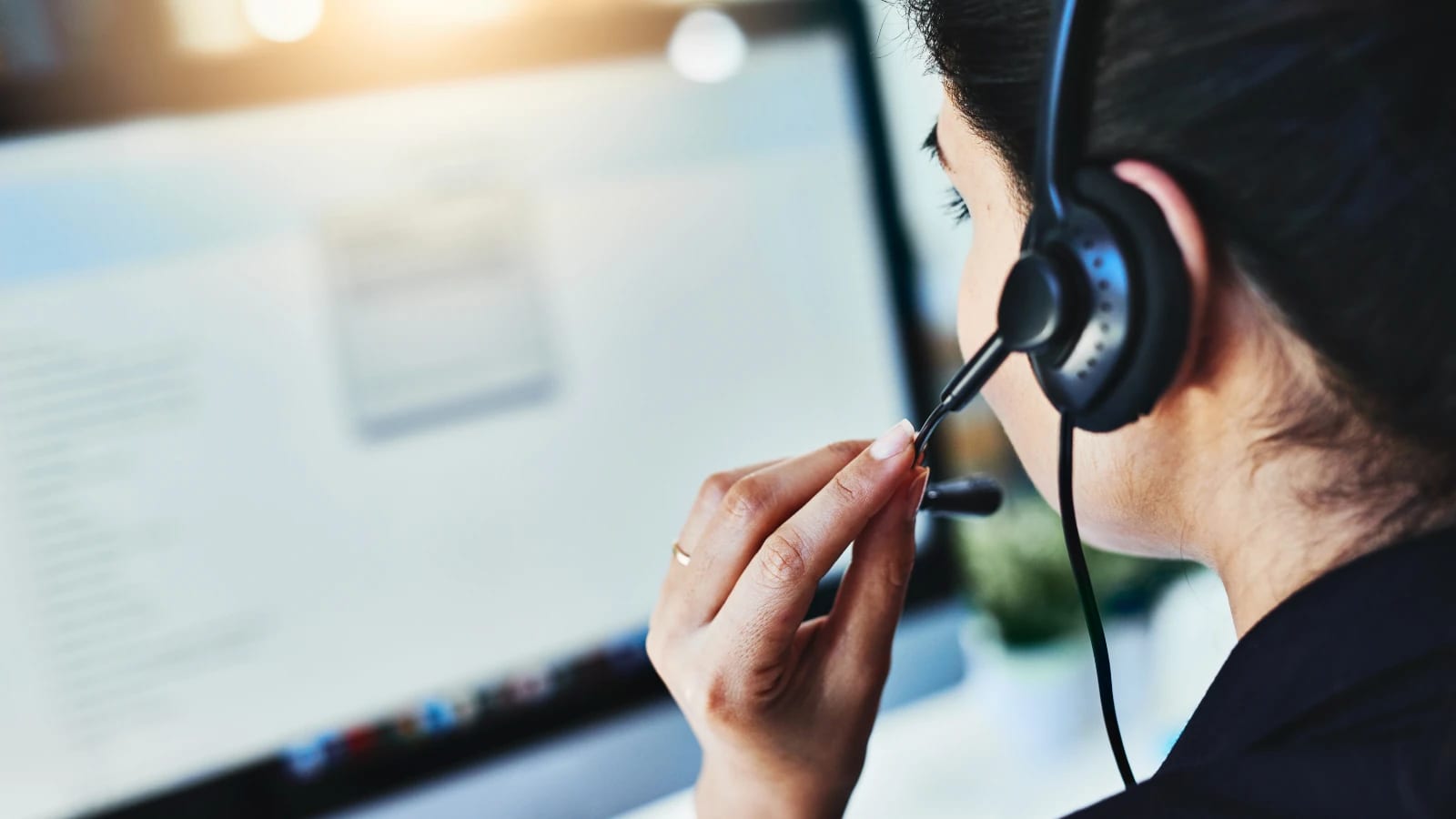 A customer service rep wearing a headset at a computer, booking hot tub removal appointments