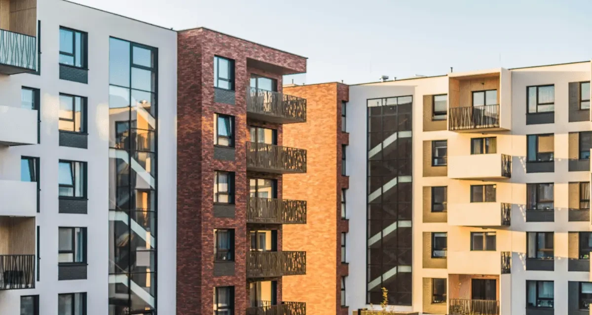 Modern apartment buildings with balconies and brick and white facades in late afternoon sun
