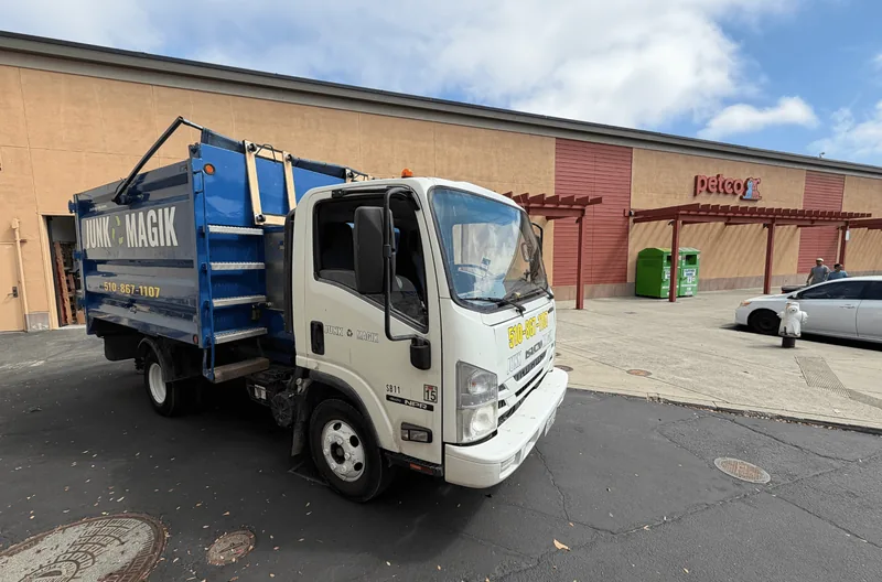The Junk Magik truck parked outside a shopping center storefront for a retail cleanout